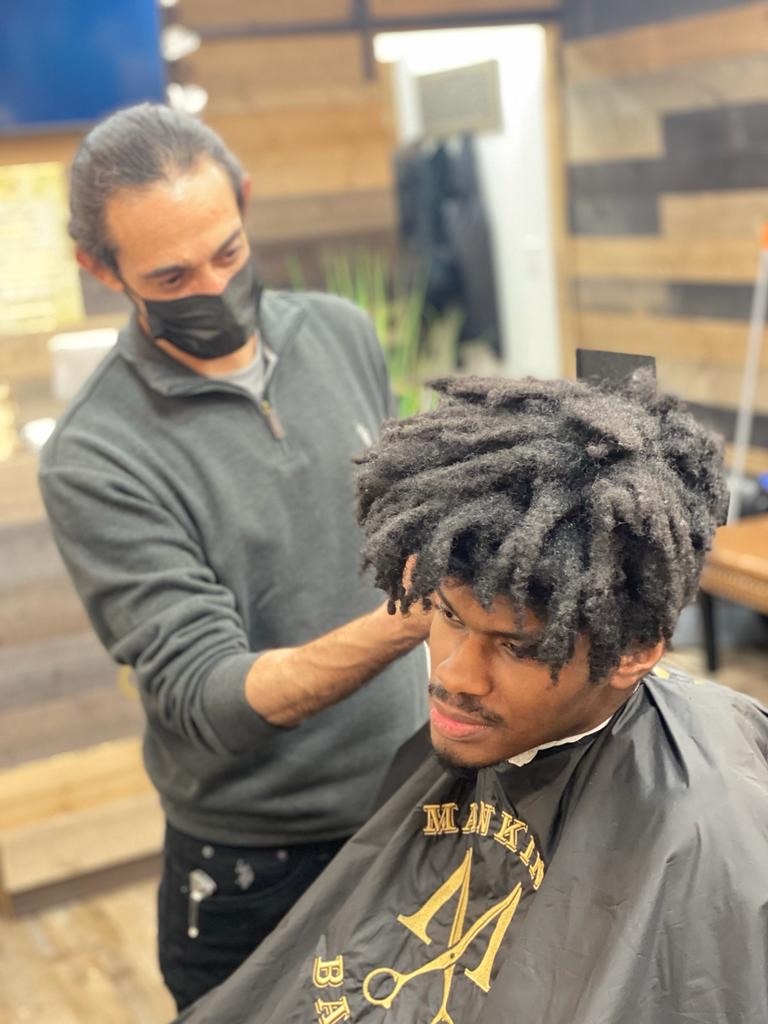 How do barbershops adapt their marketing and branding strategies to appeal to new residents moving into gentrified areas?