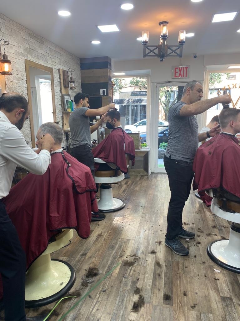 How do Lower East Side barber shops contribute to the local community and support other businesses in the area?